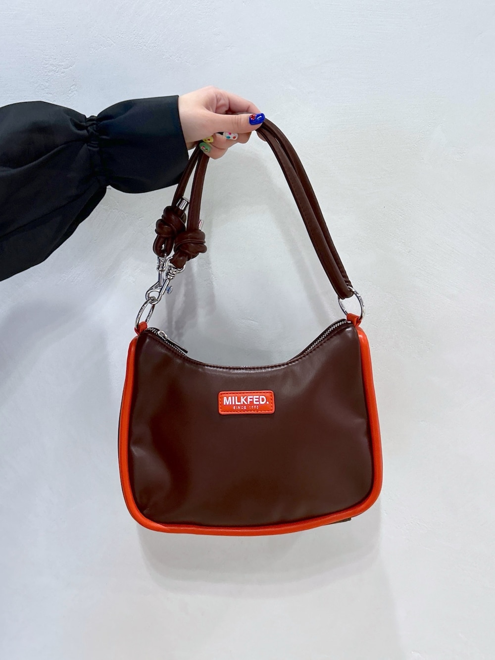 オレンジ系のTシャツ/カットソー、ブラック系のシャツ/ブラウス、ベージュ系のスカートを着用したレディースの冬コーディネートの7枚目の写真