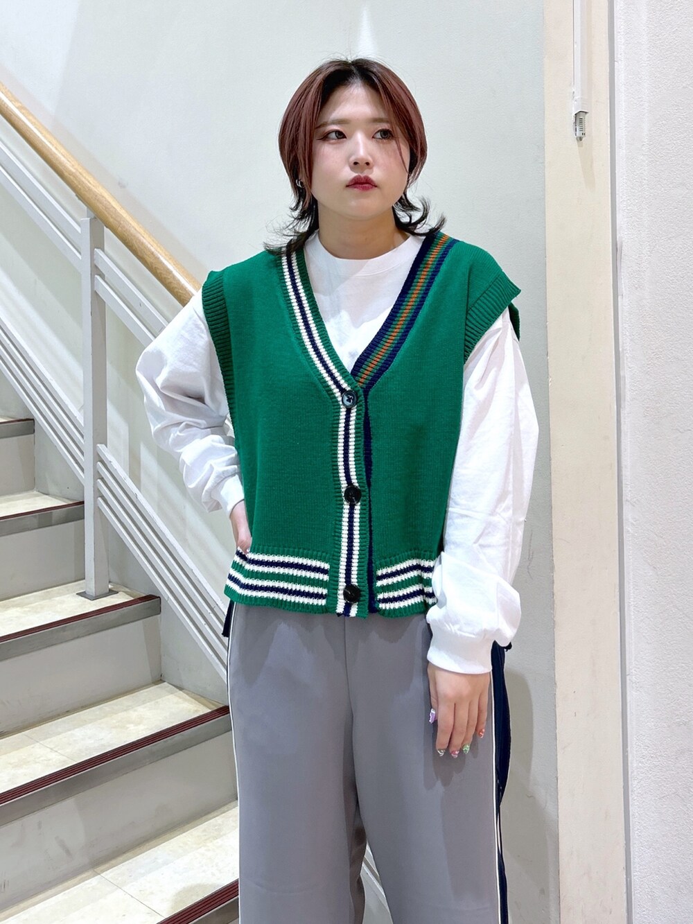 ホワイト系のTシャツ/カットソー、グリーン系のベスト、グレー系のその他パンツを着用したレディースの冬コーディネートの5枚目の写真