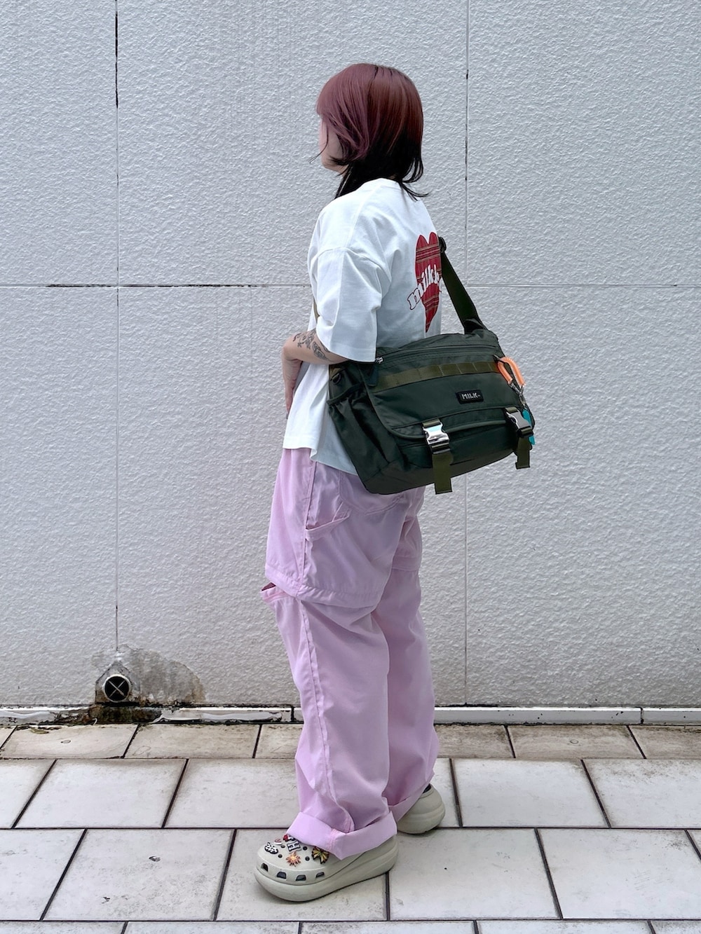 ピンク系のその他パンツ、グリーン系のメッセンジャーバッグ、ホワイト系のTシャツ/カットソーを着用したレディースの春コーディネートの2枚目の写真