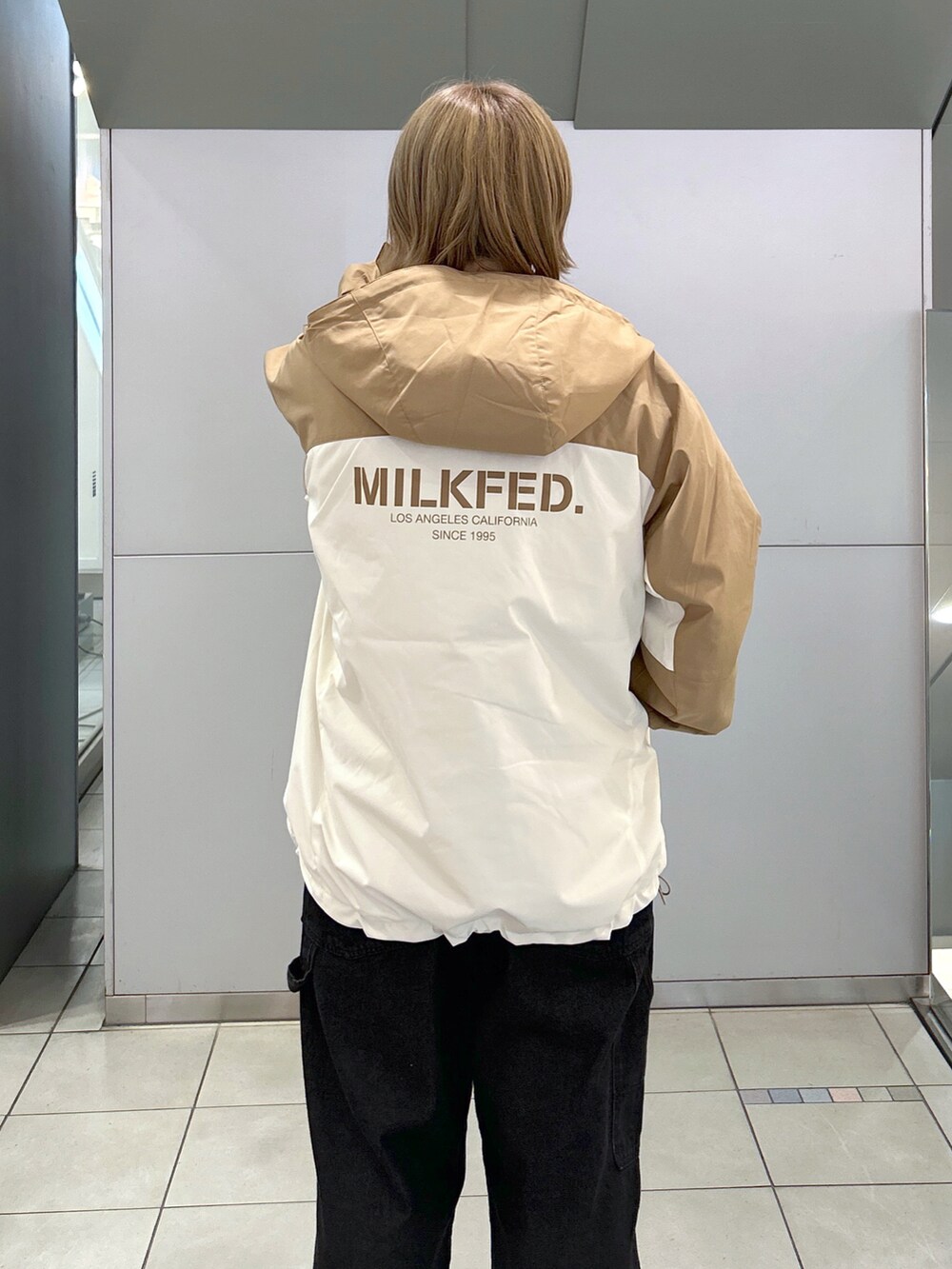 ベージュ系のマウンテンパーカー、ピンク系のニット/セーター、ブラック系のサロペット/オーバーオールを着用したレディースの秋コーディネートの4枚目の写真