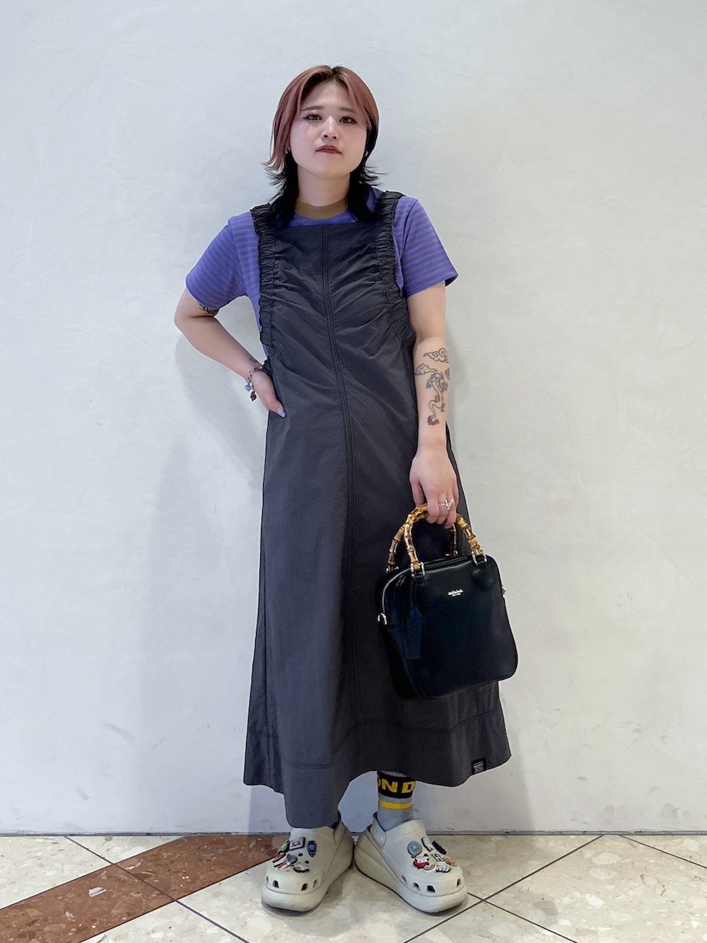 パープル系のTシャツ/カットソー、グレー系のワンピース、ブラック系のショルダーバッグを着用したレディースの春コーディネートの3枚目の写真