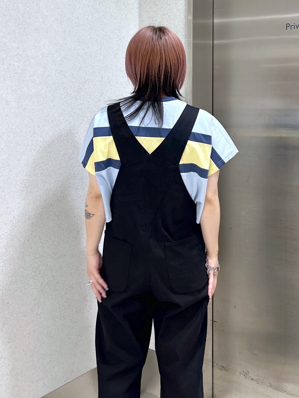 ブラック系のサロペット/オーバーオール、ブラック系のショルダーバッグ、ベージュ系のサンダルを着用したレディースの夏コーディネートの6枚目の写真