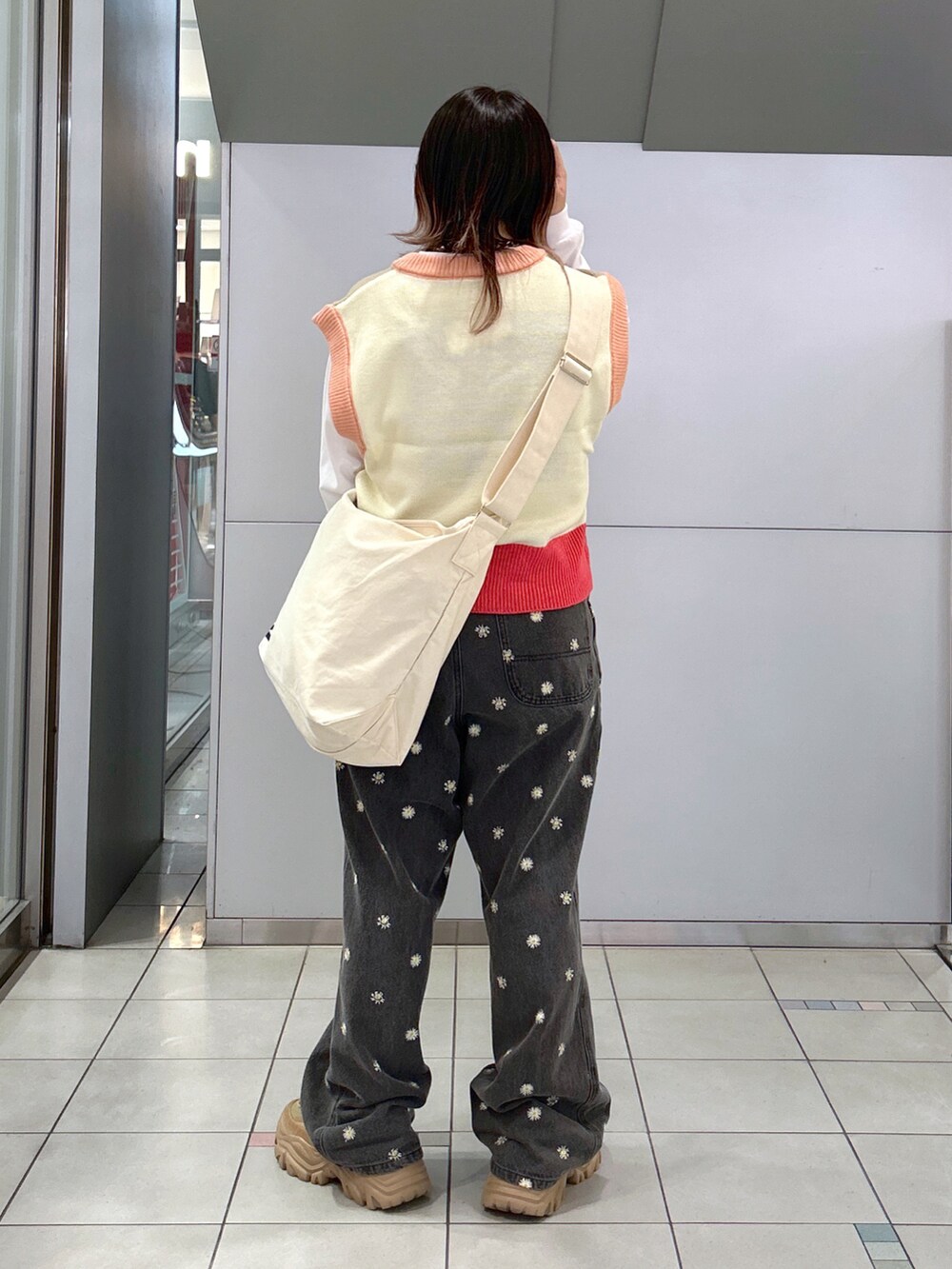 ベージュ系のベスト、ホワイト系のTシャツ/カットソー、ホワイト系のショルダーバッグを着用したレディースの秋コーディネートの2枚目の写真