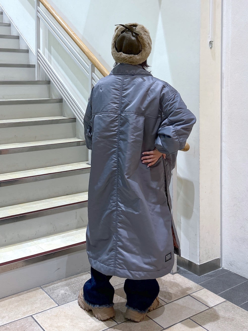 グレー系のMA-1、ブルー系のデニムパンツ、ベージュ系のスニーカーを着用したレディースの秋コーディネートの3枚目の写真