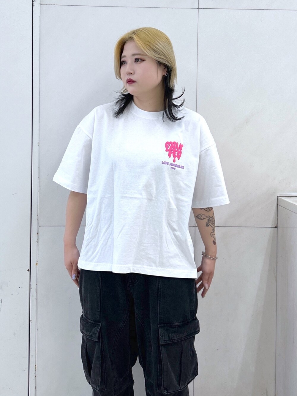 ブラック系のカーゴパンツ、ホワイト系のTシャツ/カットソー、ブラウン系のボストンバッグを着用したレディースの春コーディネートの3枚目の写真