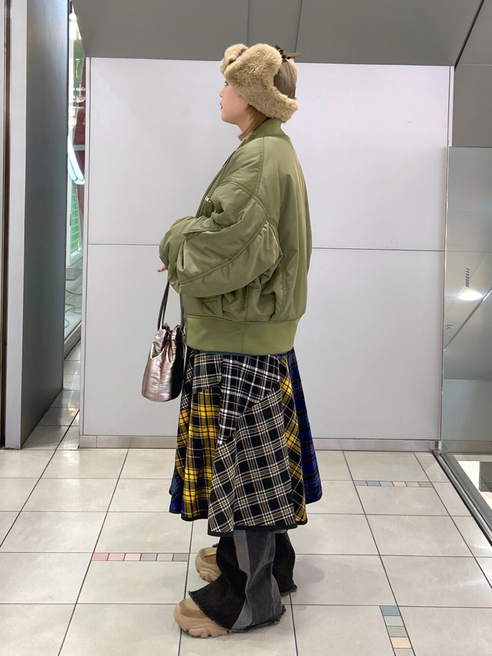 グリーン系のスウェット、グリーン系のMA-1、ブラック系のスカートを着用したレディースの冬コーディネートの2枚目の写真
