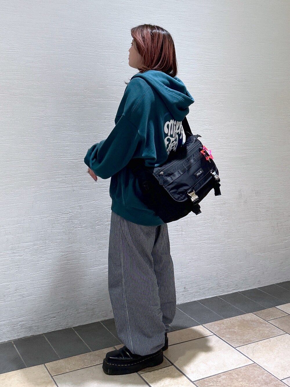 グリーン系のパーカー、その他のサロペット/オーバーオール、ブラック系のメッセンジャーバッグを着用したレディースの春コーディネートの4枚目の写真
