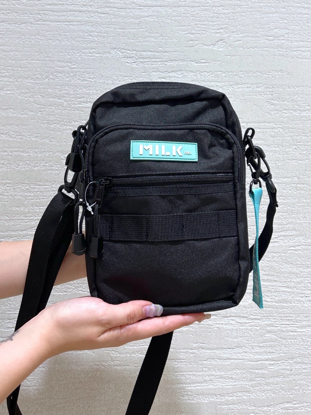 グレー系のTシャツ/カットソー、グリーン系のショルダーバッグ、ベージュ系のタンクトップを着用したレディースの春コーディネートの6枚目の写真