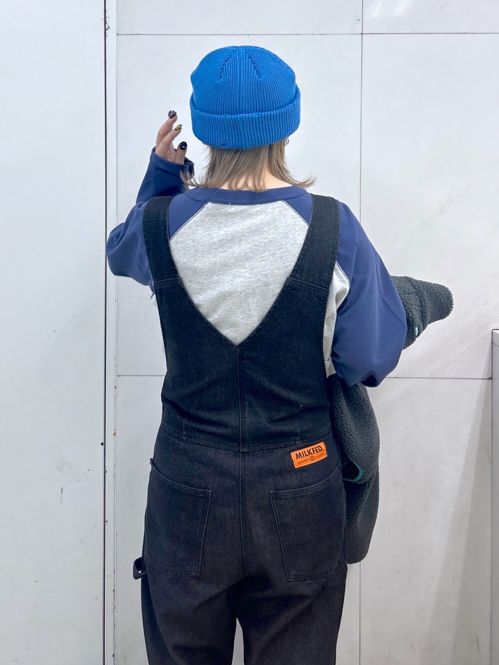 グレー系のブルゾン、ブルー系のTシャツ/カットソー、ブラック系のサロペット/オーバーオールを着用したレディースの秋コーディネートの5枚目の写真