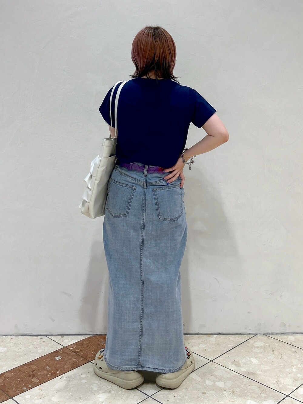 ブルー系のTシャツ/カットソー、ブルー系のデニムスカート、ホワイト系のトートバッグを着用したレディースの夏コーディネートの4枚目の写真