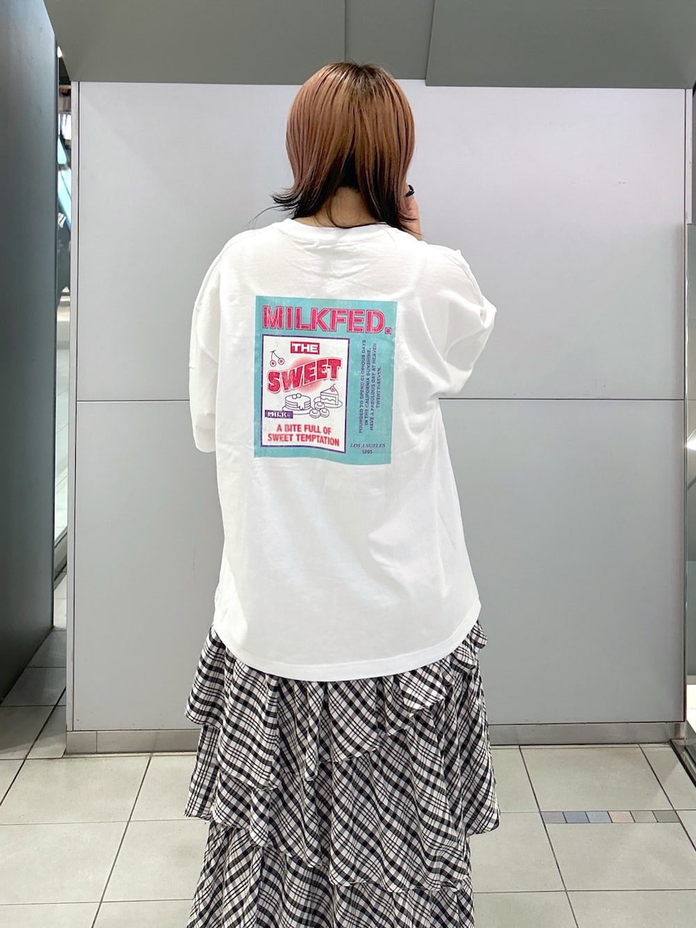 ホワイト系のTシャツ/カットソー、ブラック系のスカート、ベージュ系のサンダルを着用したレディースの夏コーディネートの3枚目の写真