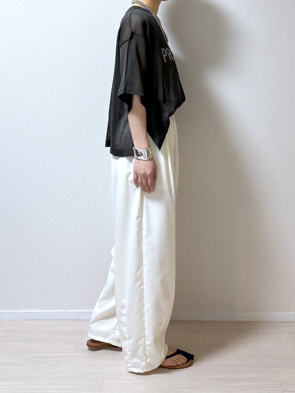 グレー系のニット/セーター、ホワイト系のその他パンツを着用したレディースの夏コーディネートの2枚目の写真