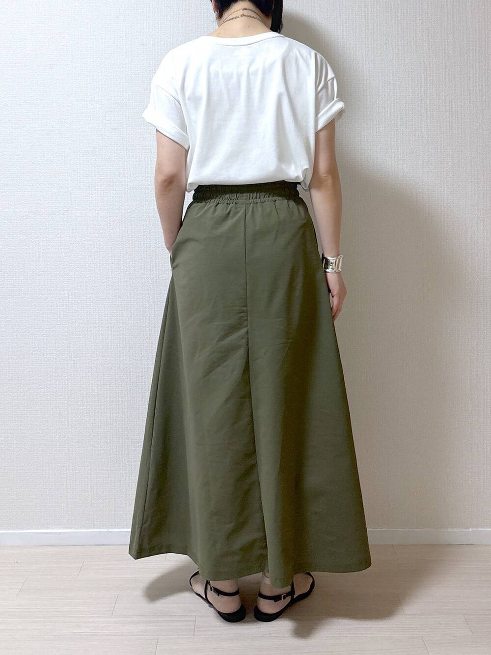 ブラック系のサンダル、ホワイト系のTシャツ/カットソー、グリーン系のスカートを着用したレディースの春コーディネートの4枚目の写真