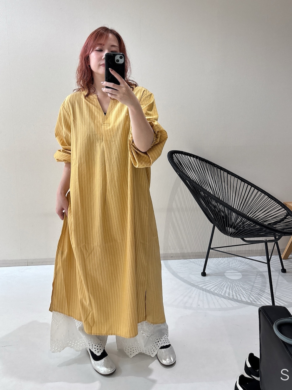 シルバー系のバレエシューズ、イエロー系のワンピース、ホワイト系のパンツを着用したレディースの冬コーディネートの2枚目の写真