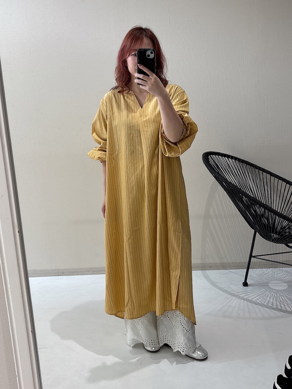 シルバー系のバレエシューズ、イエロー系のワンピース、ホワイト系のパンツを着用したレディースの冬コーディネートの3枚目の写真