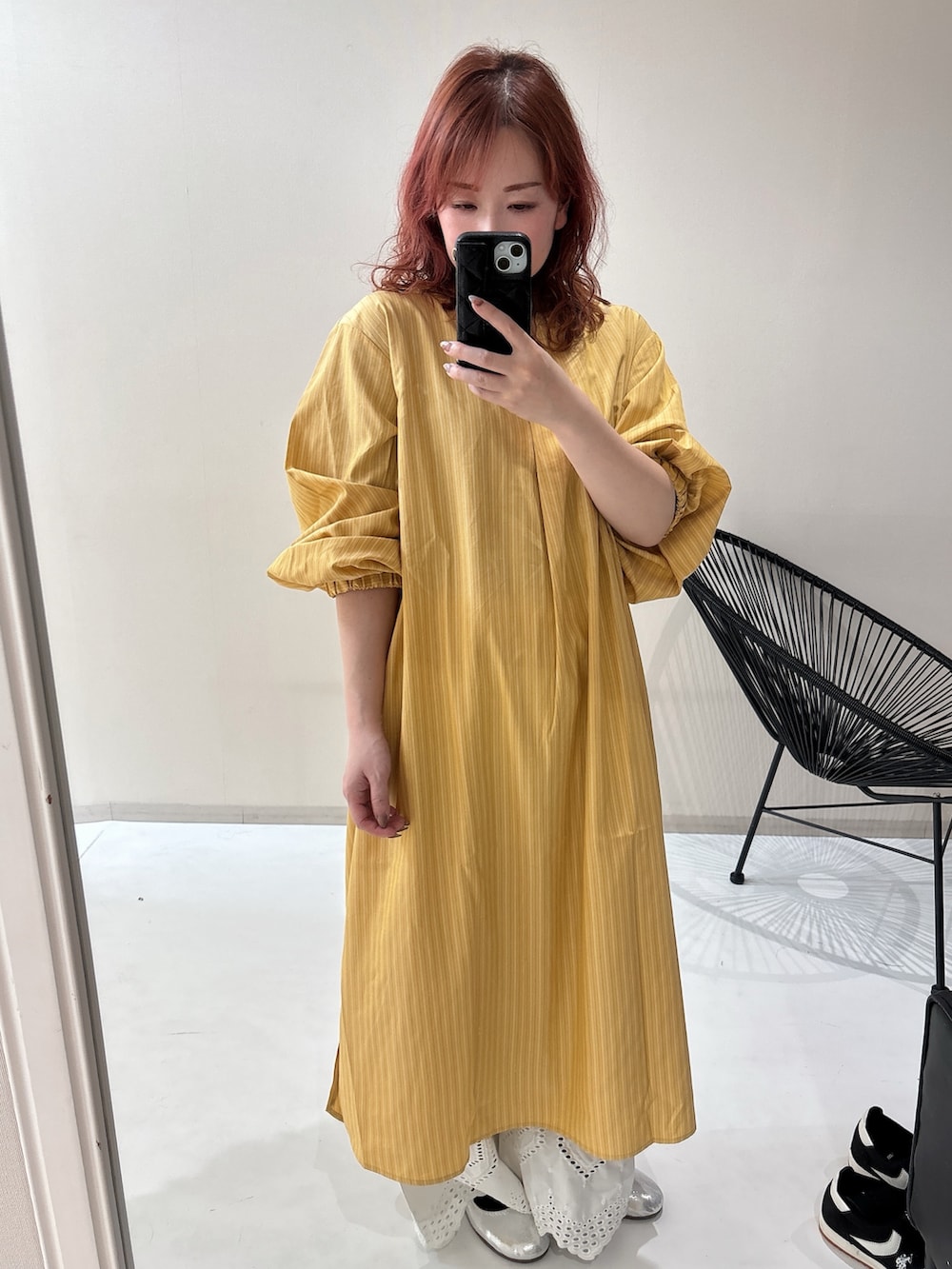 シルバー系のバレエシューズ、イエロー系のワンピース、ホワイト系のパンツを着用したレディースの冬コーディネートの6枚目の写真