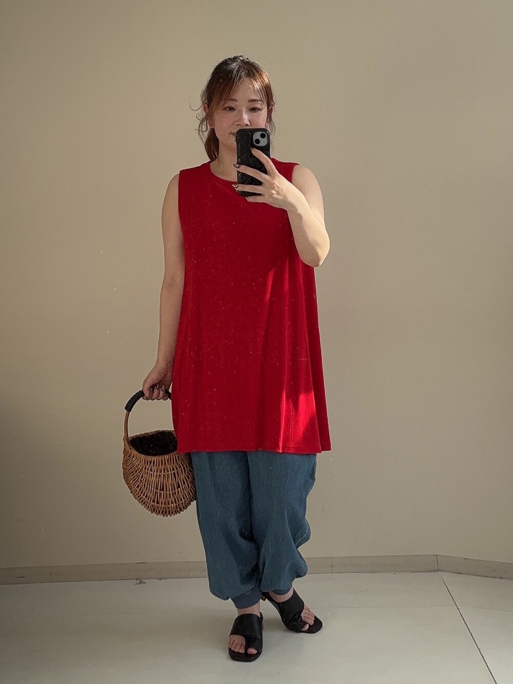 レッド系のチュニック、ブルー系のパンツ、ブラック系のサンダルを着用したレディースの夏コーディネートの3枚目の写真