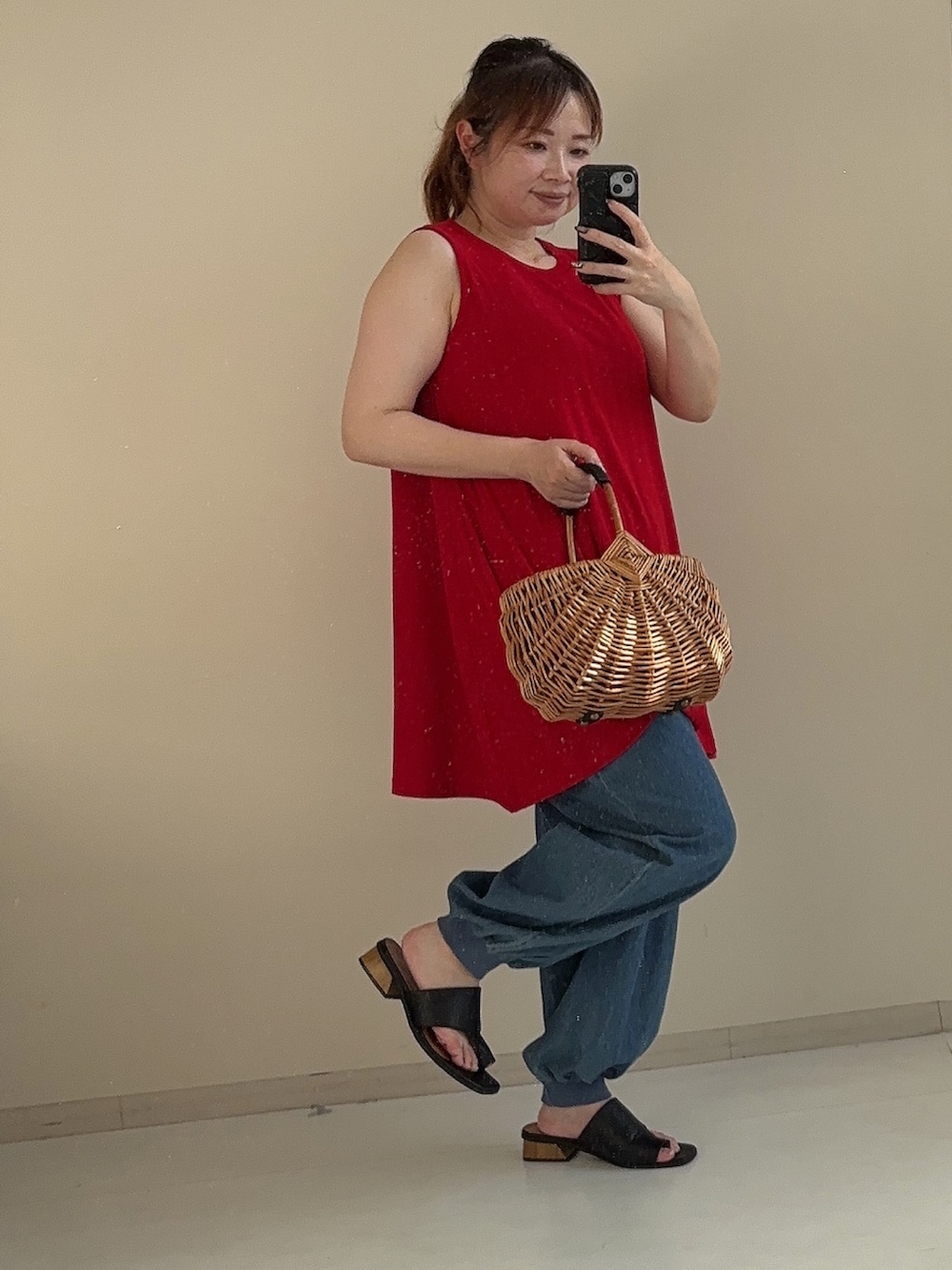 レッド系のチュニック、ブルー系のパンツ、ブラック系のサンダルを着用したレディースの夏コーディネートの4枚目の写真
