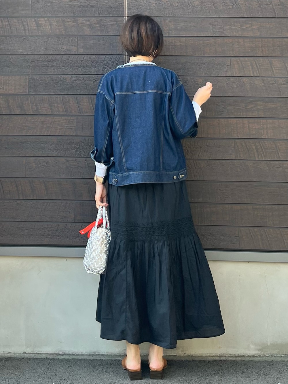 「春コーデ、大人カジュアル、春服コーデ、高身長コーデ、春服デビュー宣言、デニムジャケット、骨格ナチュラル、ティアードスカート、ロンT、ロゴT、ミュール、編みバッグ、シルバー」｜「Green　Parksのノーカラーデニムジャケット（デニムジャケット、ブルー系）」を使った、yokoyama_yuuuさん（レディース・173cm）の春コーディネートの3枚目の写真