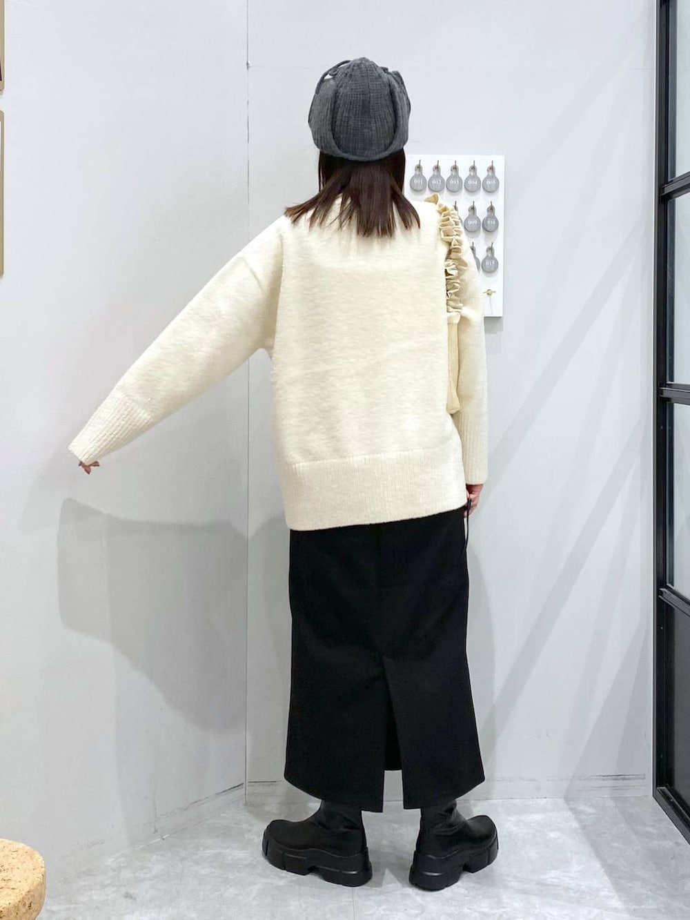 ブラック系のブーツ、ブラック系のスカート、ホワイト系のショルダーバッグを着用したレディースの冬コーディネートの3枚目の写真