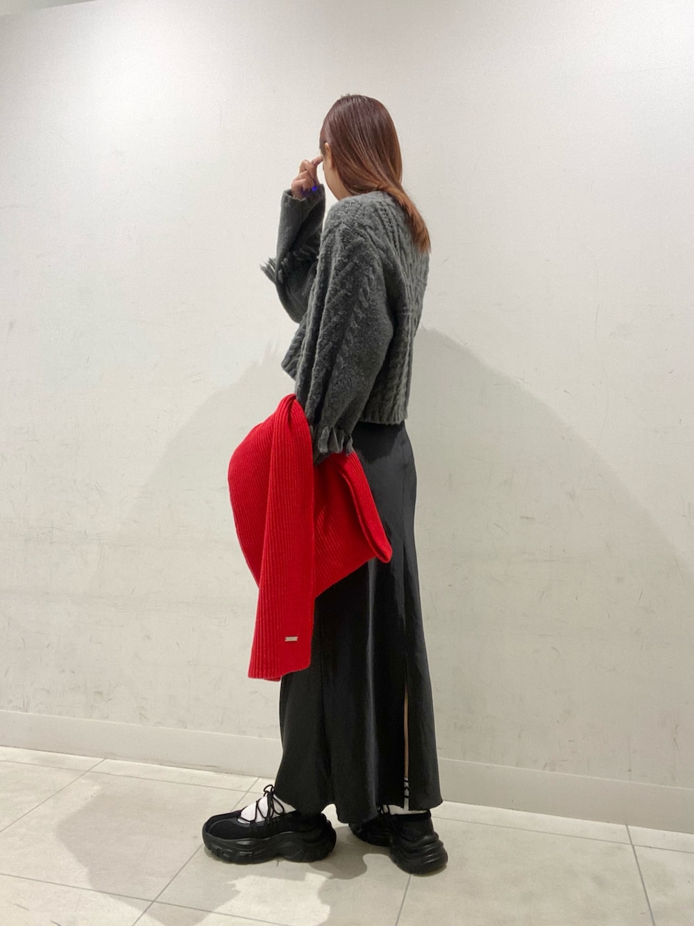 グレー系のカーディガン/ボレロ、ブラック系のスカート、ブラック系のスニーカーを着用したレディースの秋コーディネートの3枚目の写真