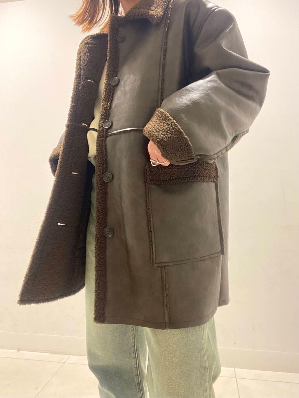 ホワイト系のトートバッグ、ブルー系のその他パンツ、ブラウン系のブルゾンを着用したレディースの冬コーディネートの3枚目の写真