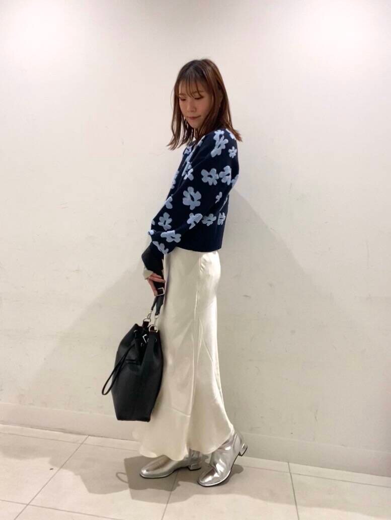シルバー系のブーツ、ホワイト系のTシャツ/カットソー、ブラック系のショルダーバッグを着用したレディースの冬コーディネートの2枚目の写真