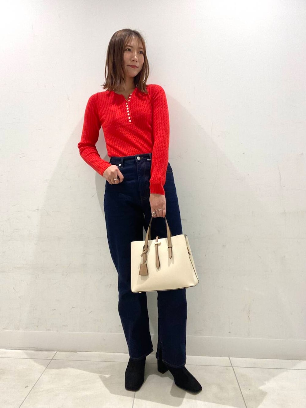 ホワイト系のトートバッグ、ブラック系のブーツ、グレー系のその他アウターを着用したレディースの冬コーディネートの3枚目の写真