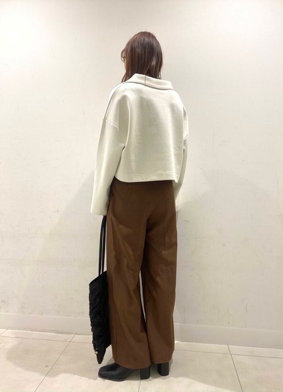 ブラック系のブーツ、ブラック系のトートバッグ、ブラウン系のその他パンツを着用したレディースの冬コーディネートの2枚目の写真