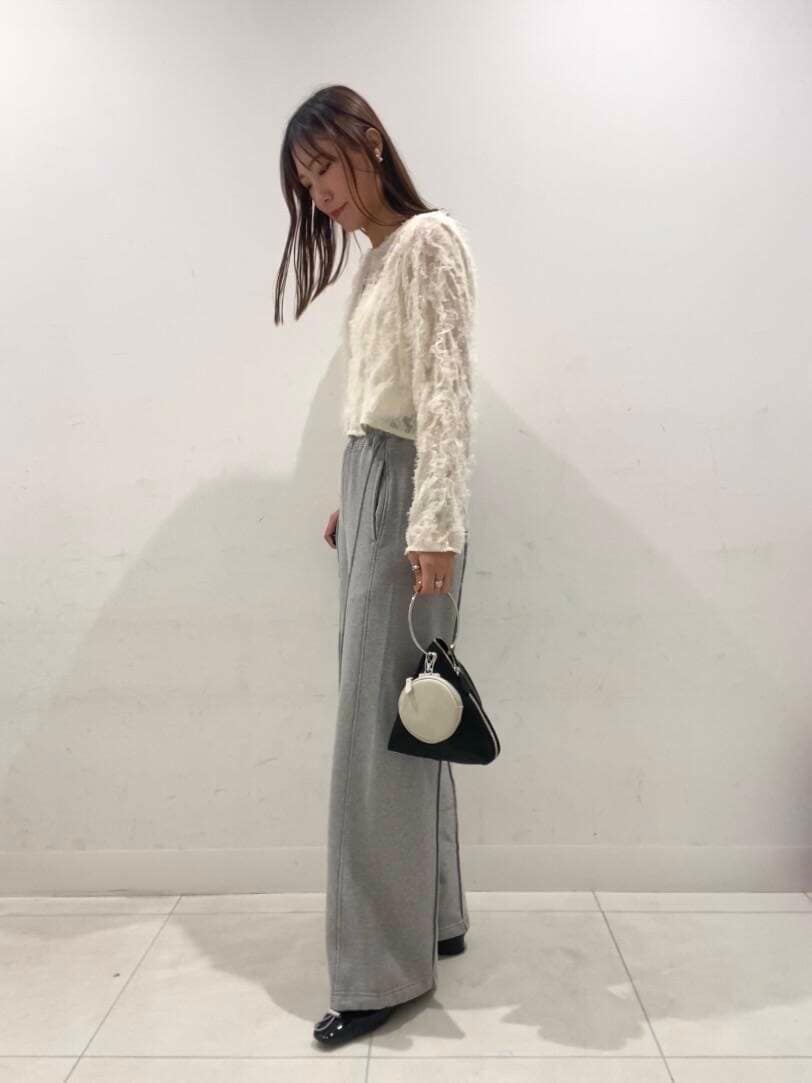 ブラック系のパンプス、ブラック系のハンドバッグ、ホワイト系のキャミソールを着用したレディースの春コーディネートの2枚目の写真