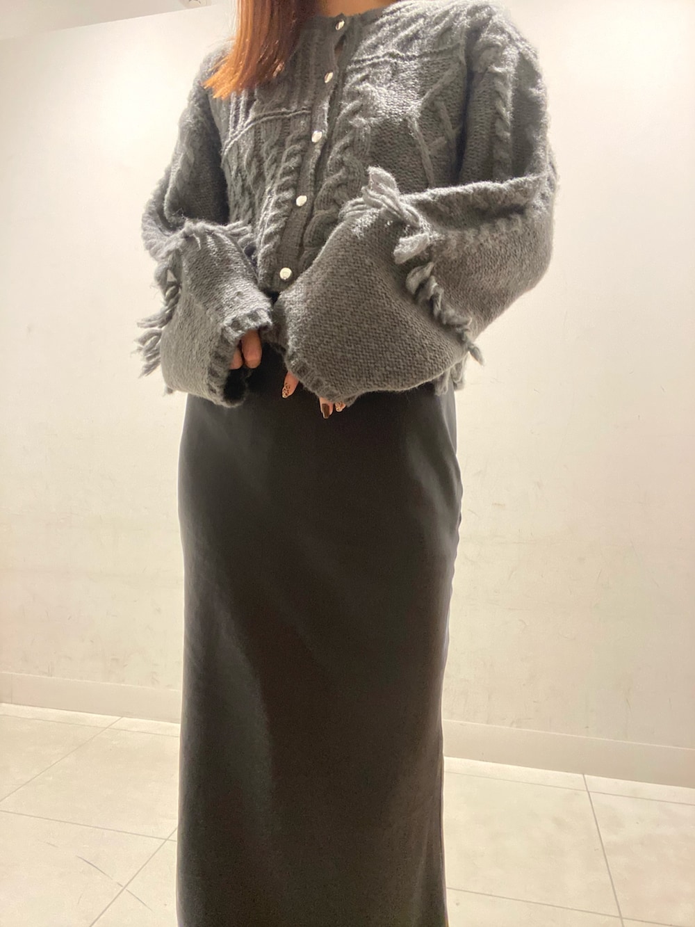 グレー系のカーディガン/ボレロ、ブラック系のスカート、ブラック系のスニーカーを着用したレディースの秋コーディネートの4枚目の写真