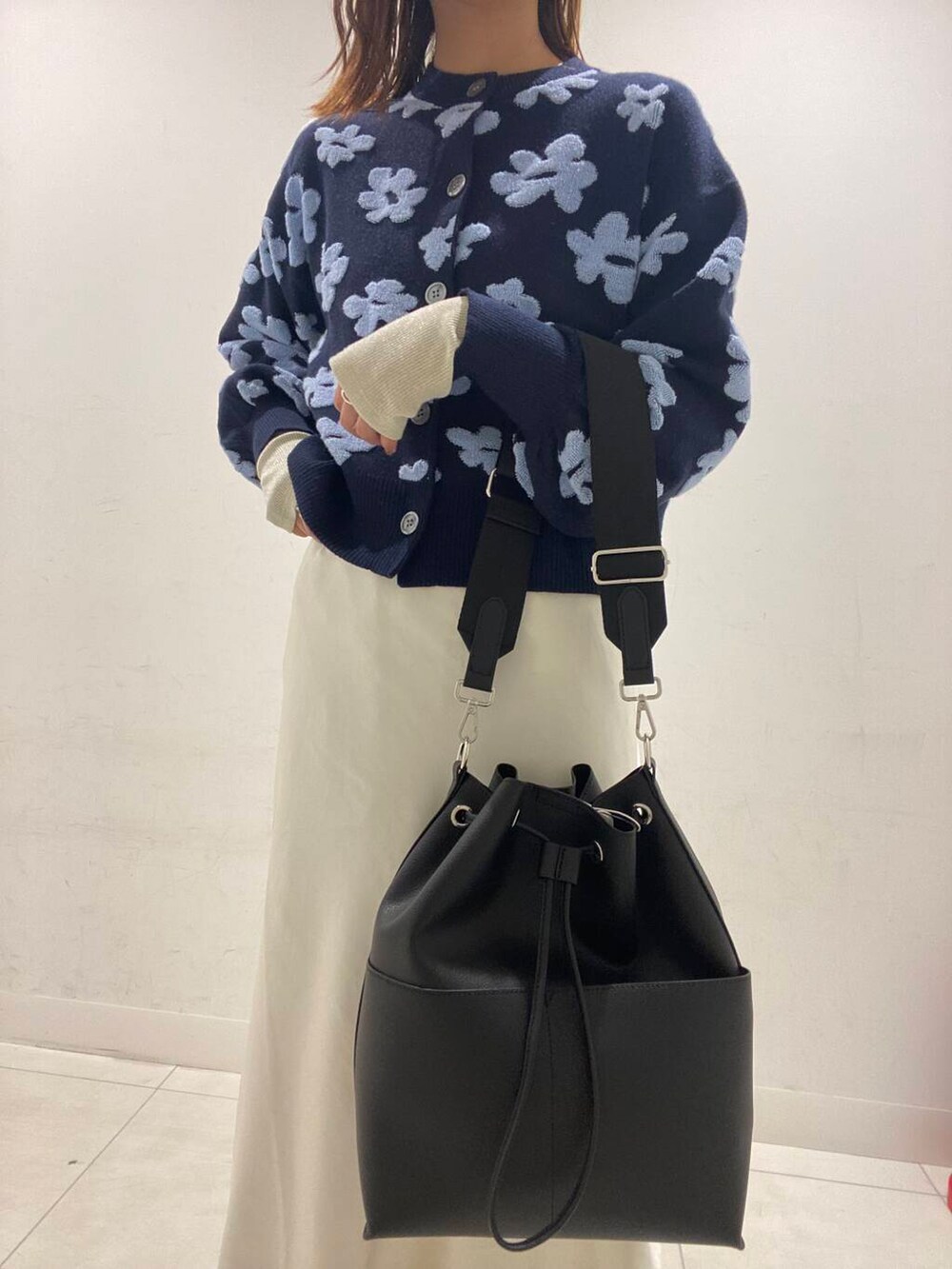 シルバー系のブーツ、ホワイト系のTシャツ/カットソー、ブラック系のショルダーバッグを着用したレディースの冬コーディネートの3枚目の写真