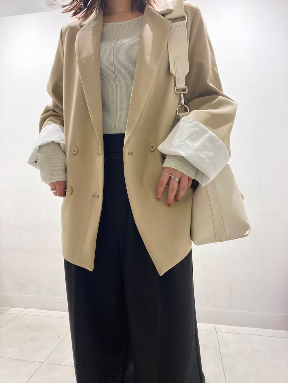 ブラック系のその他パンツ、グレー系のスニーカー、ベージュ系のテーラードジャケットを着用したレディースの冬コーディネートの2枚目の写真