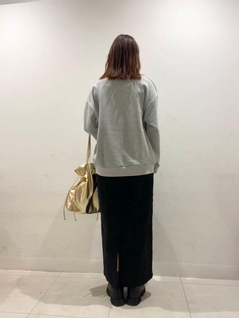 ゴールド系のトートバッグ、ブラック系のスカート、その他のスウェットを着用したレディースの冬コーディネートの3枚目の写真