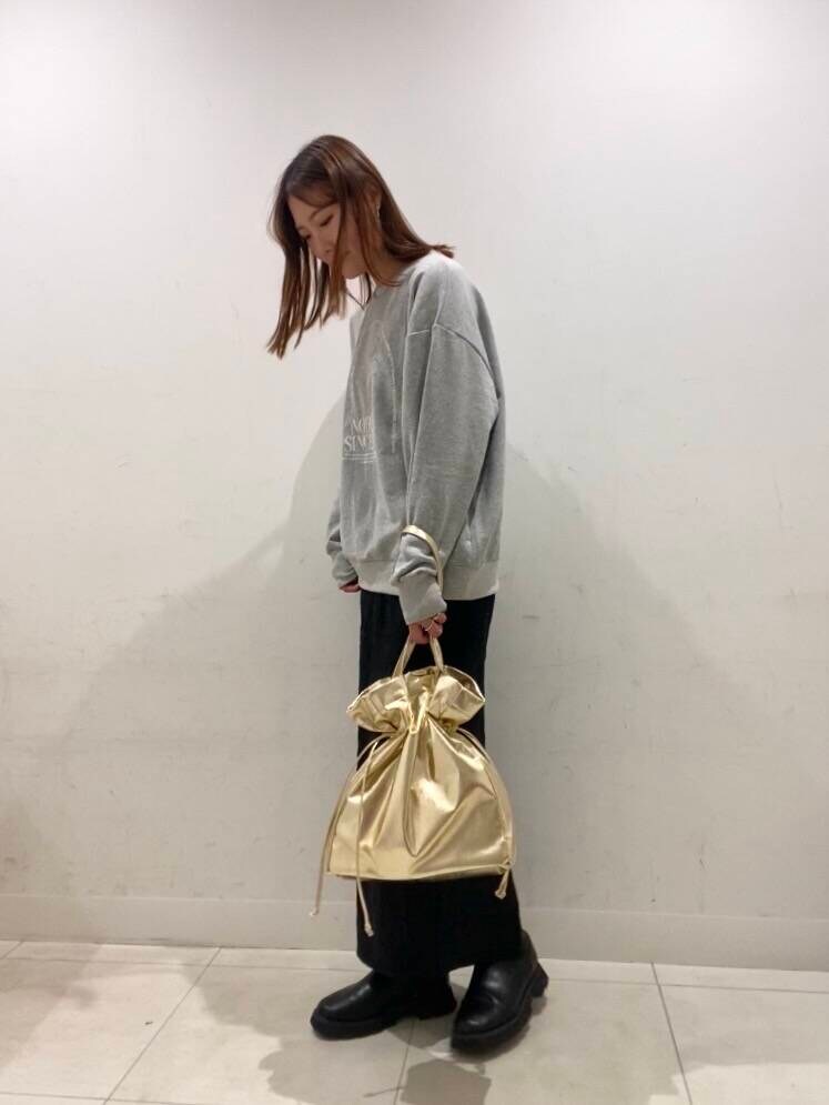 ゴールド系のトートバッグ、ブラック系のスカート、その他のスウェットを着用したレディースの冬コーディネートの2枚目の写真