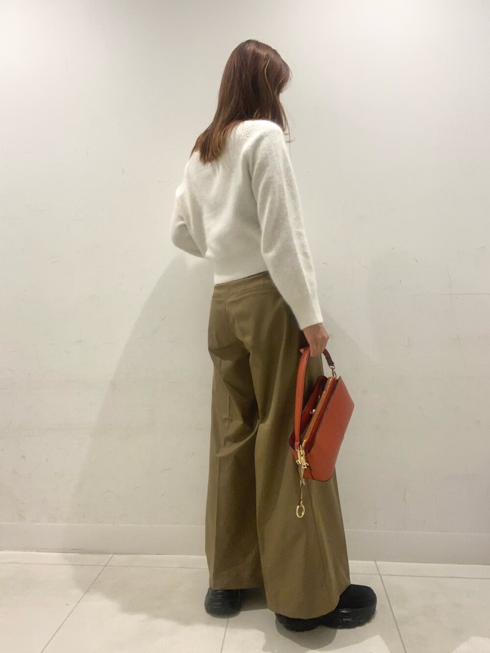 ホワイト系のニット/セーター、ベージュ系のその他パンツ、オレンジ系のショルダーバッグを着用したレディースの秋コーディネートの3枚目の写真