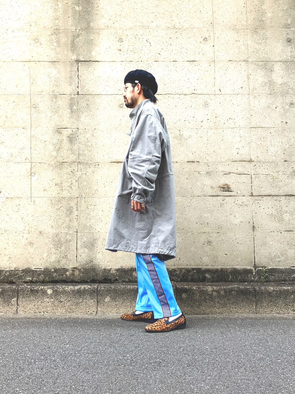 ブラック系のモッズコート、イエロー系のTシャツ/カットソー、ブルー系のデニムパンツを着用したメンズの春コーディネートの2枚目の写真