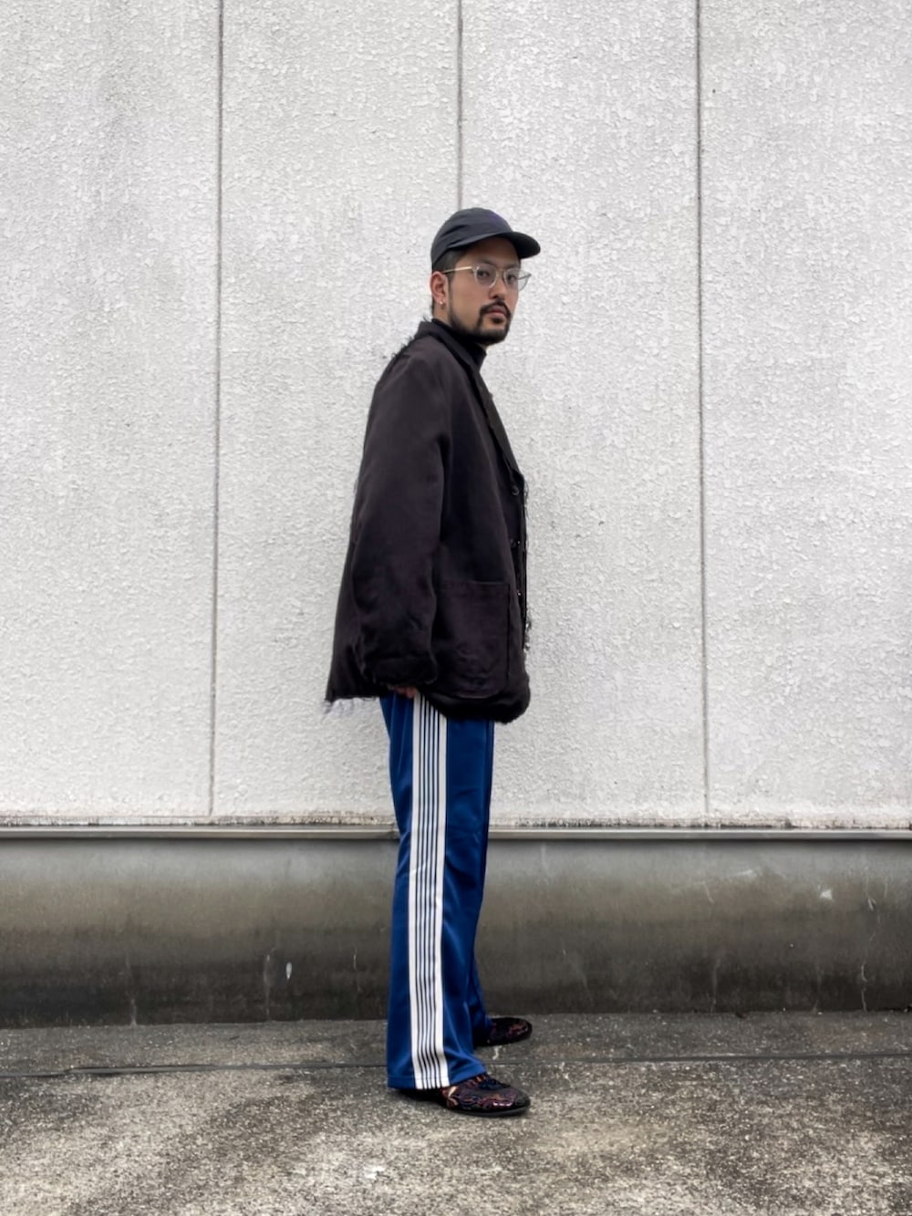 ブラウン系のテーラードジャケット、ブルー系のパンツを着用したメンズの秋コーディネートの2枚目の写真