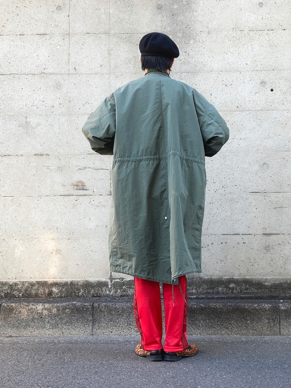 グリーン系のモッズコート、ブルー系のカバーオール、レッド系のデニムパンツを着用したメンズの冬コーディネートの3枚目の写真