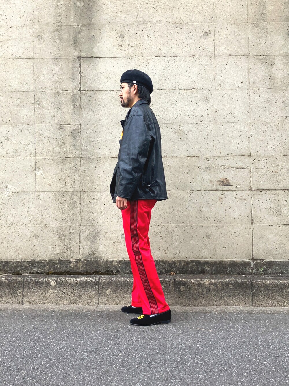 ブラック系のライダースジャケット、ブルー系のTシャツ/カットソー、レッド系のデニムパンツを着用したメンズの春コーディネートの3枚目の写真