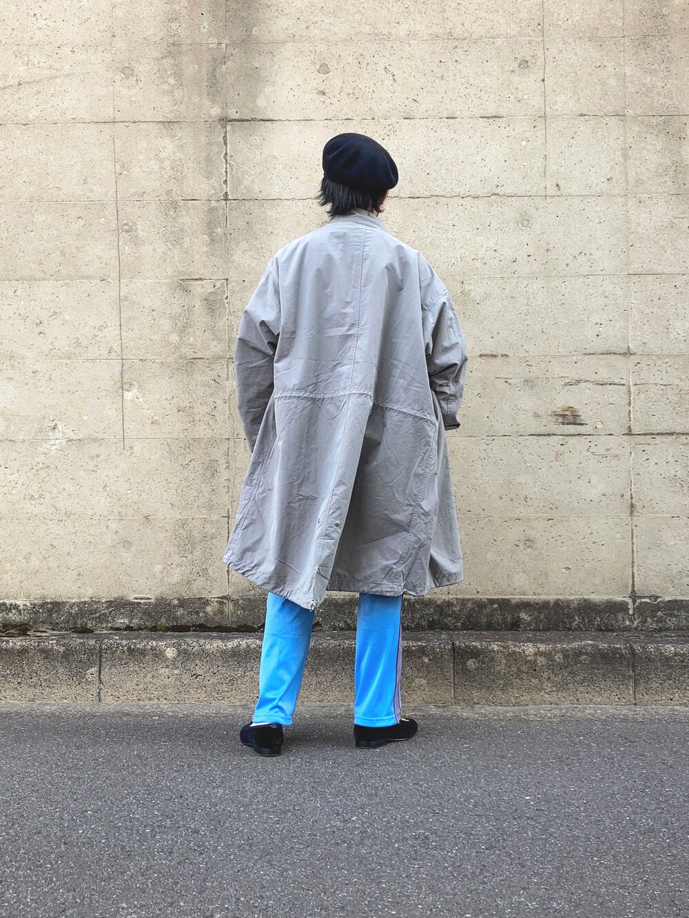 グレー系のモッズコート、イエロー系のスウェット、ブルー系のデニムパンツを着用したメンズの春コーディネートの3枚目の写真