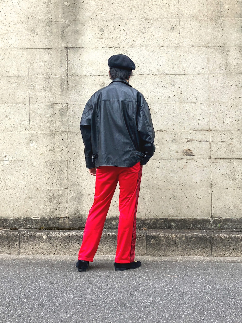 ブラック系のライダースジャケット、ブルー系のTシャツ/カットソー、レッド系のデニムパンツを着用したメンズの春コーディネートの4枚目の写真