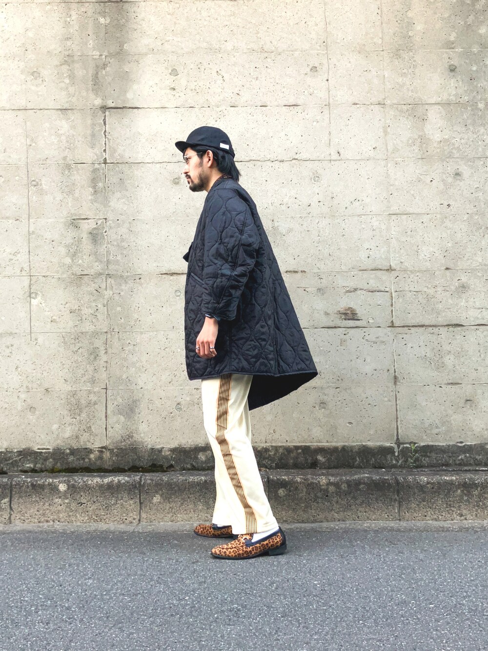 ブラック系のモッズコート、ブルー系のTシャツ/カットソー、ベージュ系のデニムパンツを着用したメンズの春コーディネートの2枚目の写真