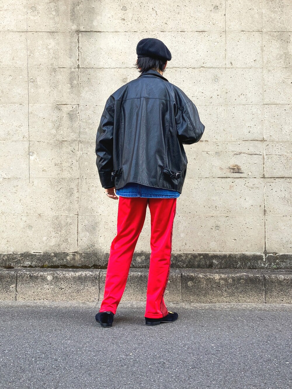 ブラック系のライダースジャケット、ブルー系のカバーオール、レッド系のデニムパンツを着用したメンズの春コーディネートの3枚目の写真