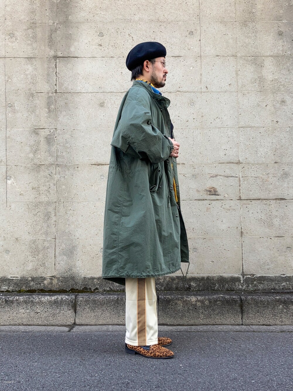 グリーン系のモッズコート、イエロー系のカーディガン/ボレロ、ブルー系のシャツ/ブラウスを着用したメンズの冬コーディネートの2枚目の写真