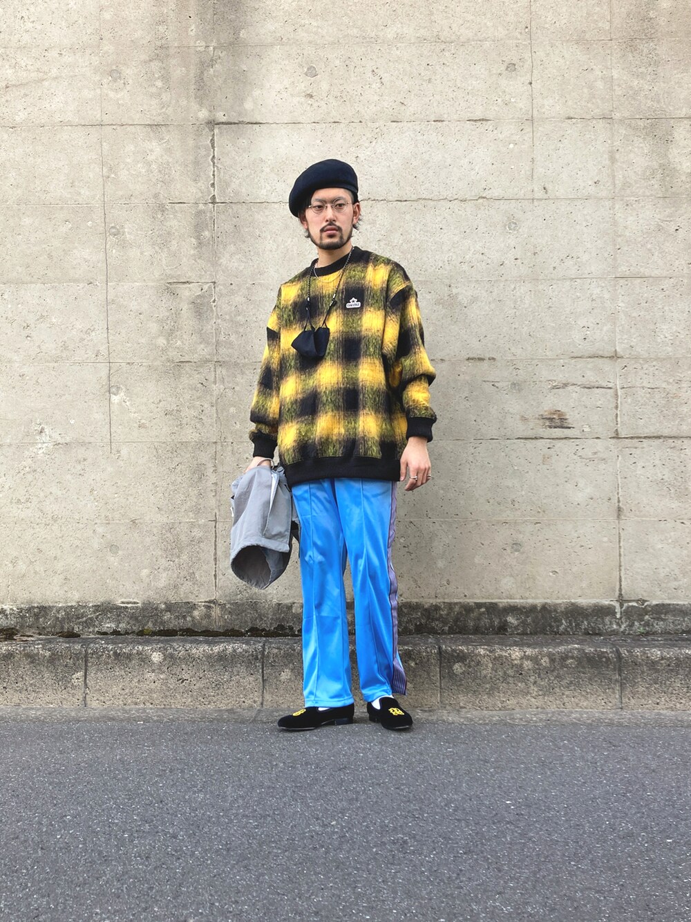 グレー系のモッズコート、イエロー系のスウェット、ブルー系のデニムパンツを着用したメンズの春コーディネートの4枚目の写真