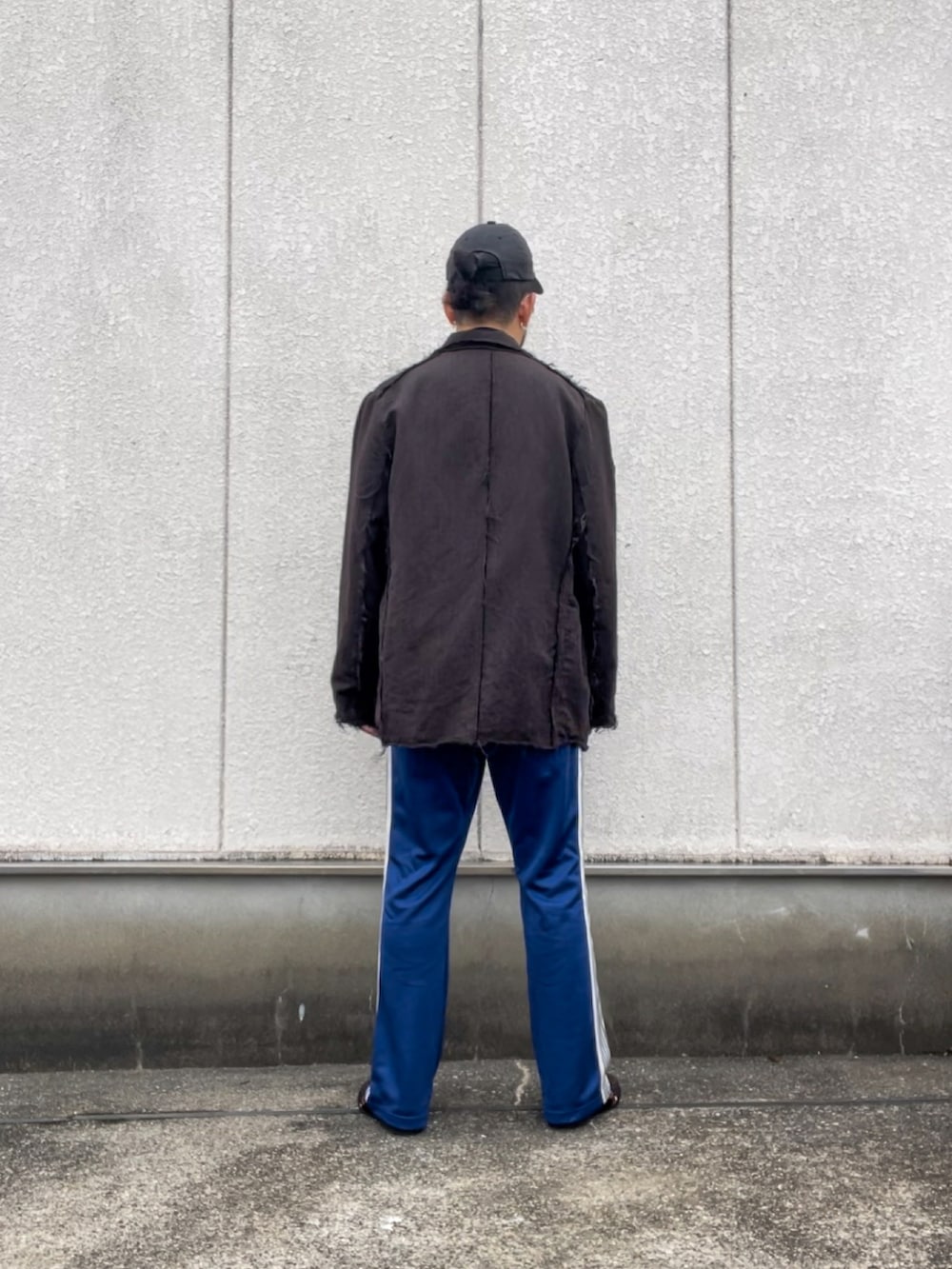 ブラウン系のテーラードジャケット、ブルー系のパンツを着用したメンズの秋コーディネートの3枚目の写真