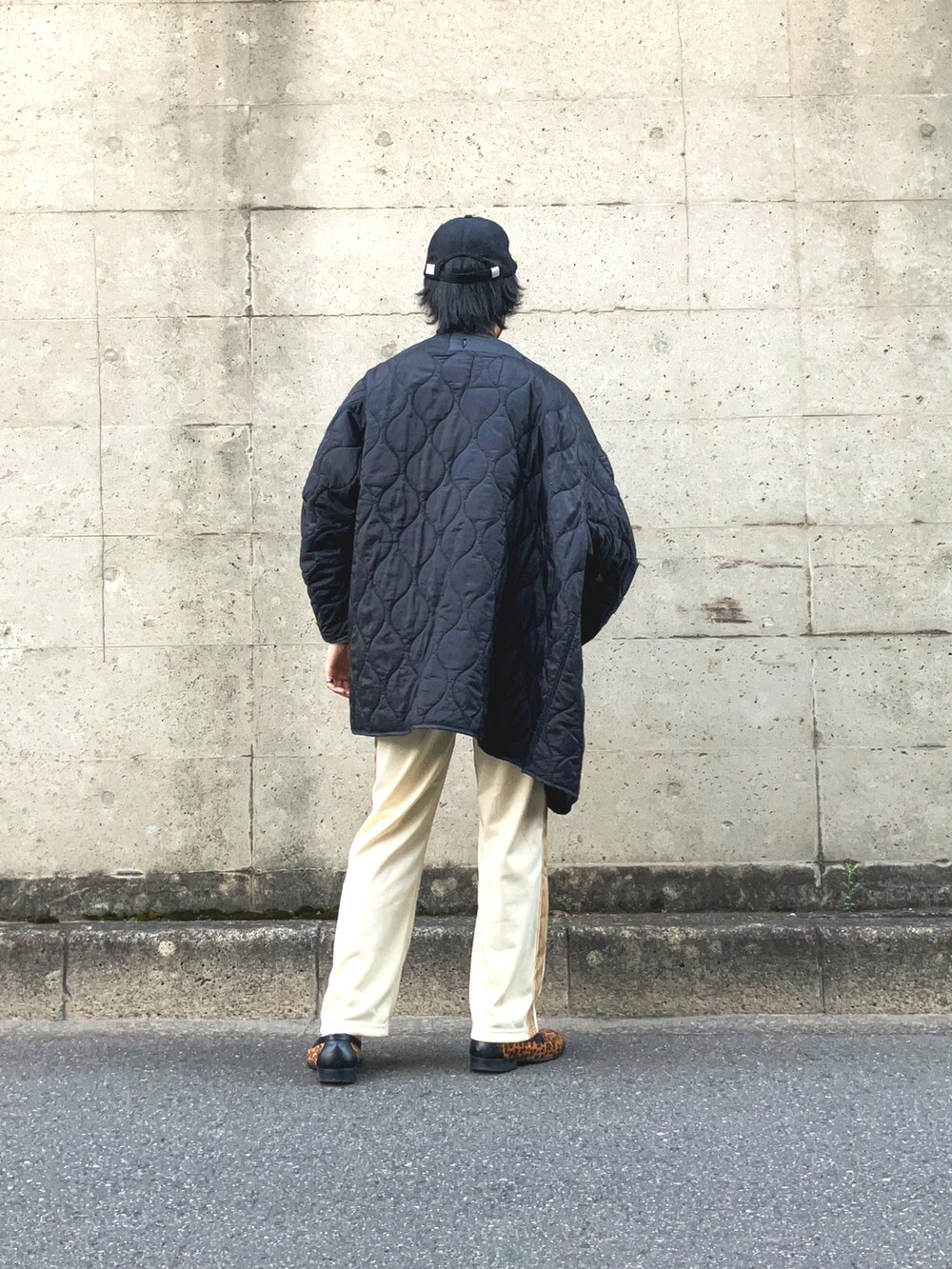 ブラック系のモッズコート、ブルー系のTシャツ/カットソー、ベージュ系のデニムパンツを着用したメンズの春コーディネートの3枚目の写真