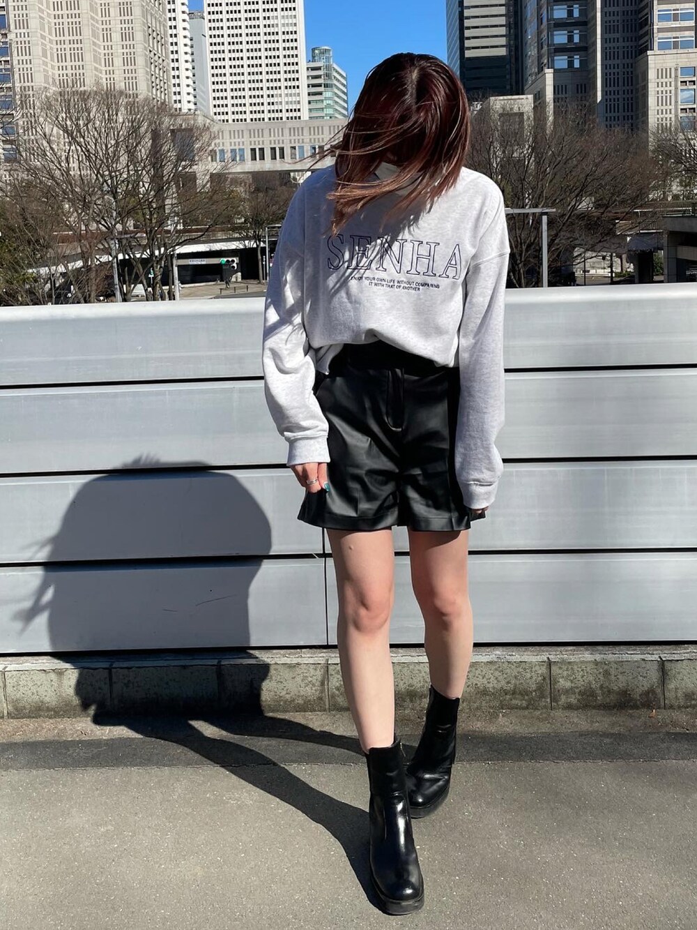 ホワイト系のスウェット、ブラック系のブーツ、ブラック系のその他パンツを着用したレディースの冬コーディネートの2枚目の写真