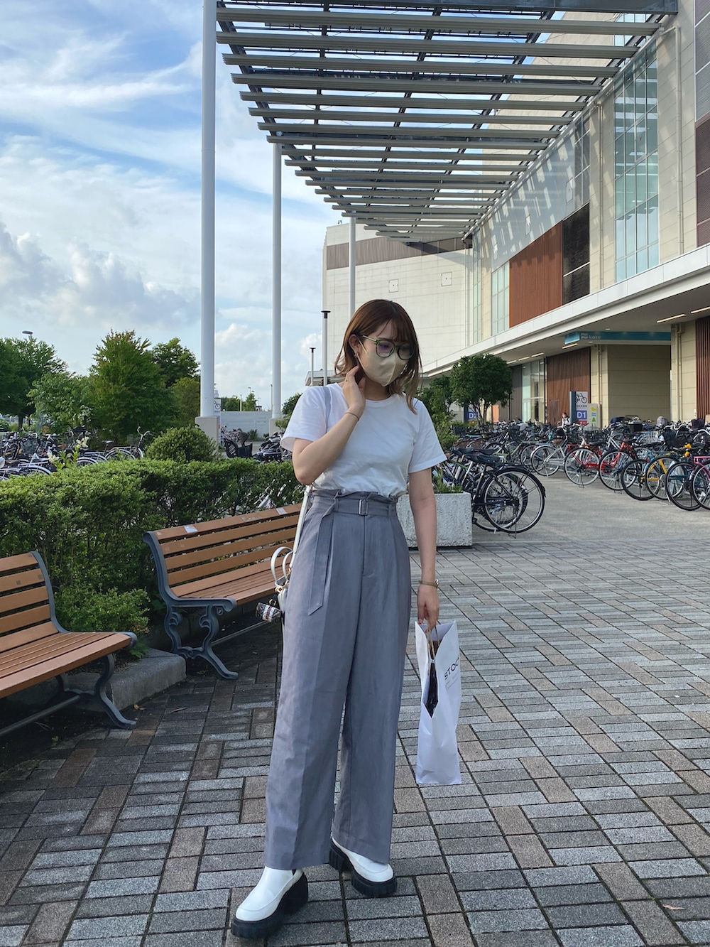 グレー系のその他パンツ、ホワイト系のTシャツ/カットソー、ホワイト系のブーツを着用したレディースの春コーディネートの2枚目の写真